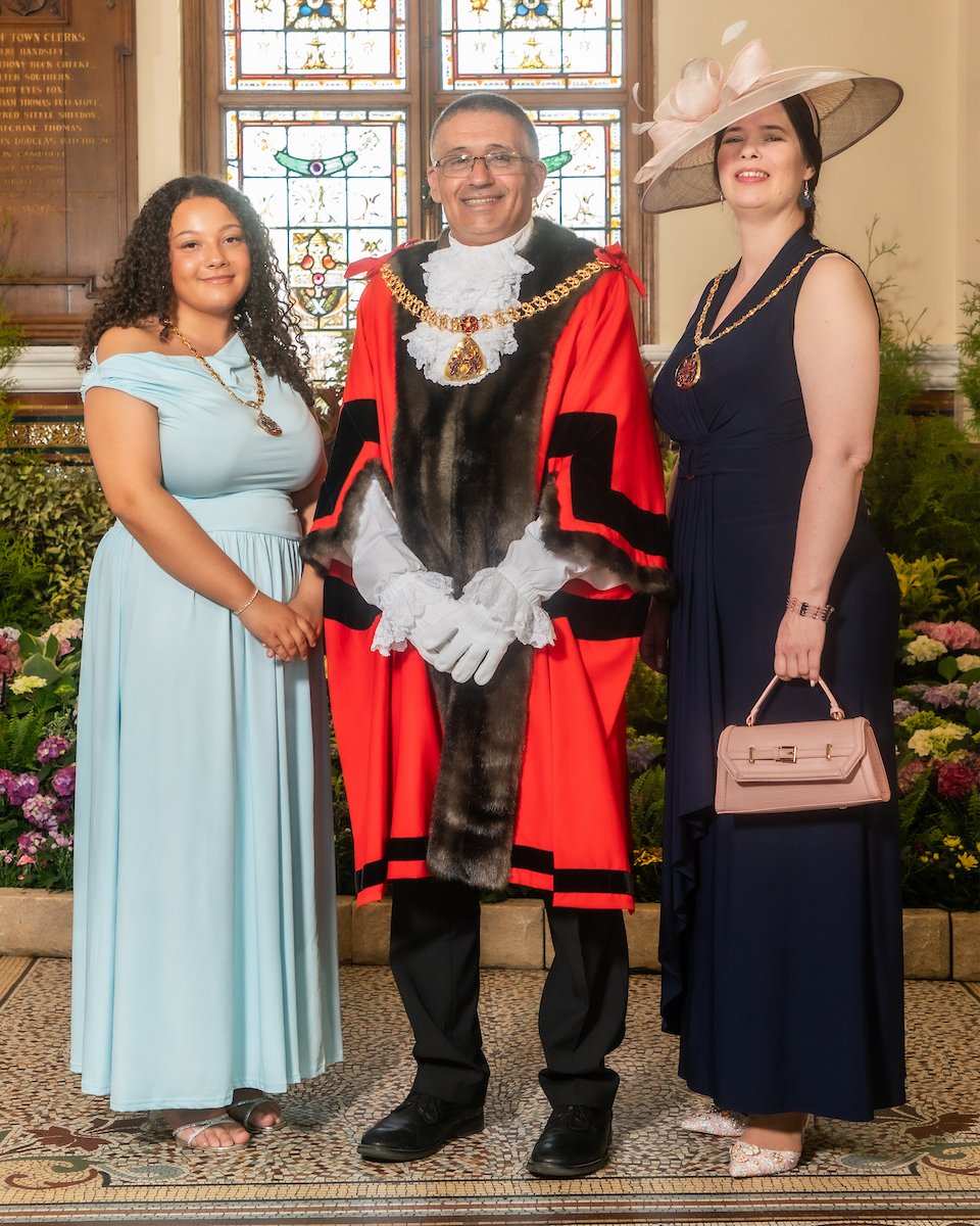 The Mayor of Burnley Cllr paul Reynolds with two mayoresses stood either side in the town hall